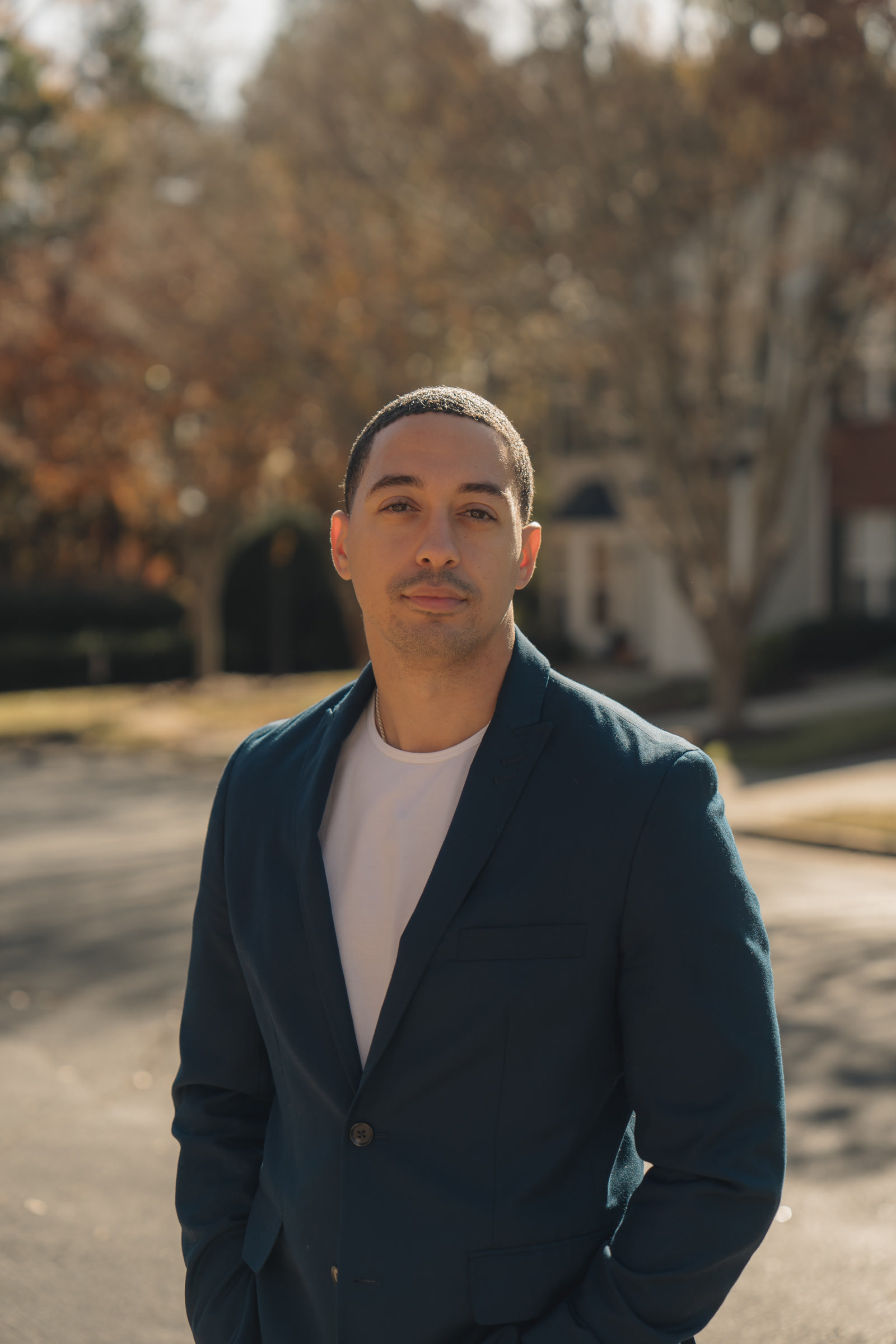 Geoff Bey standing outdoors on a tree-lined street